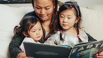 华裔家长带着孩子一起阅读中文读物